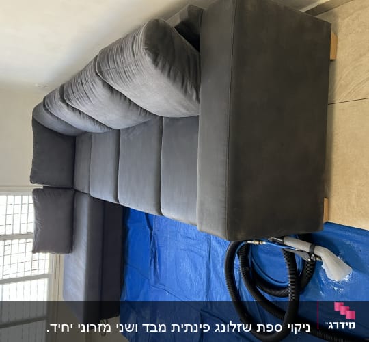 ספה אפורה עם ציוד ניקוי על יריעת פלסטיק כחולה